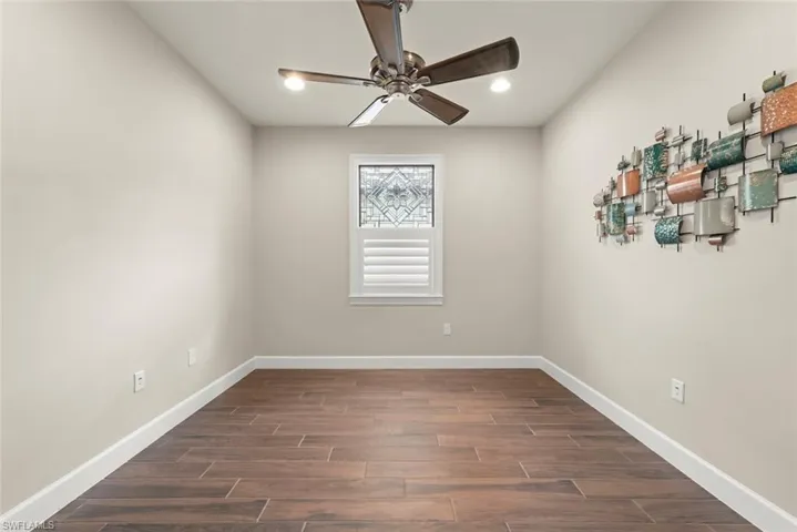 Office with tile finish floors, ceiling fan, and  a recessed lighting-leaded glass top glass with wood shutter in the bottom window