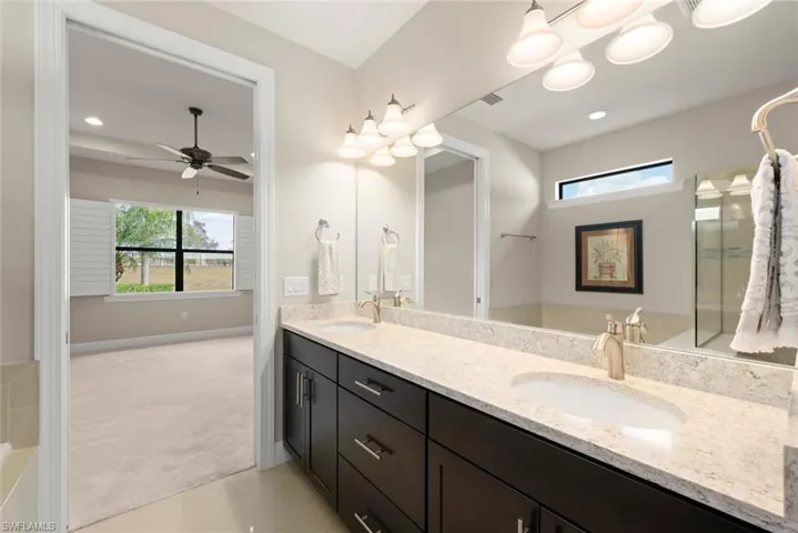 Bathroom featuring double vanity, light colored carpet, and light floor