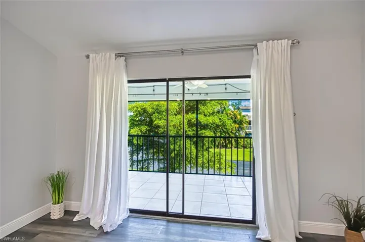 Doorway to outside with healthy amount of natural light and wood finished floors
