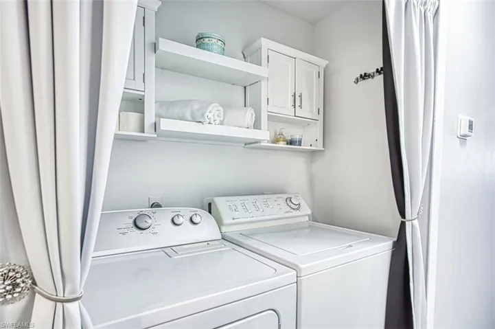 Washroom with cabinet space and washer and clothes dryer