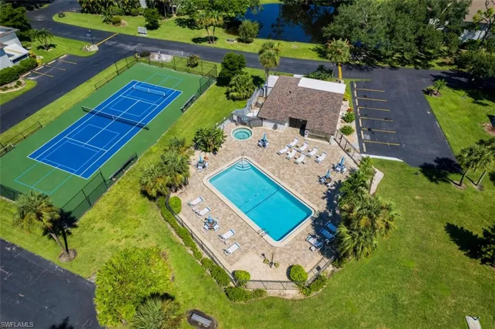 Bird's eye view of a nearby body of water and a pool area
