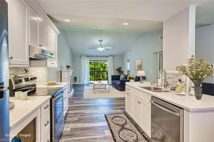 Kitchen with decorative backsplash, stainless steel appliances, white cabinets, open floor plan, and recessed lighting *VIRTUALLY STAGED