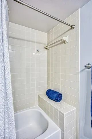 Full bathroom featuring shower / bathtub combination with curtain