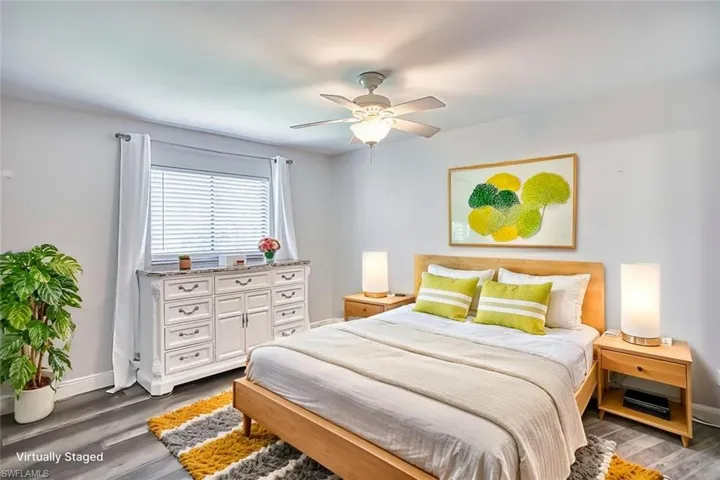 Bedroom with dark wood-style floors and a ceiling fan *VIRTUALLY STAGED