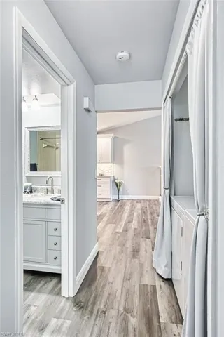 Hallway with light wood-style flooring and baseboards