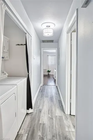 Laundry area featuring light wood-style floors and washer and dryer