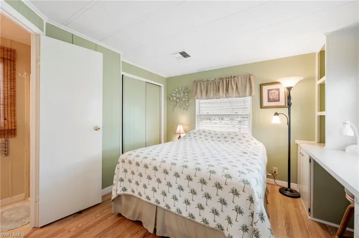 Bedroom featuring crown molding, light wood finished floors, and a closet