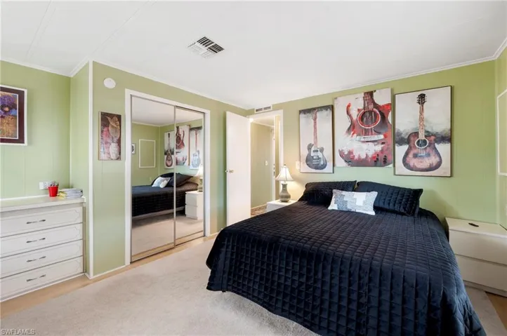Bedroom with ornamental molding, a closet, and a decorative wall