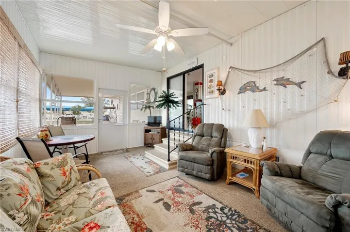 Carpeted living room with ceiling fan