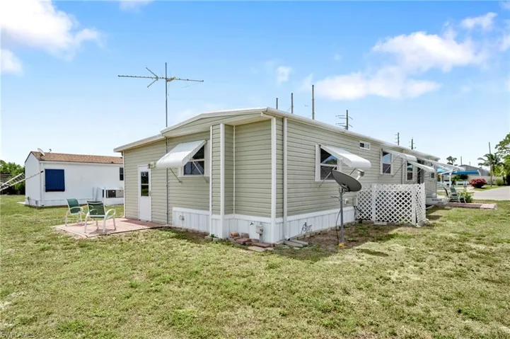 Back of property featuring a patio and a lawn