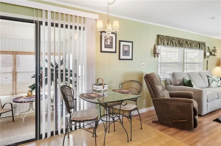 Dining space with ornamental molding, a chandelier, and wood finished floors