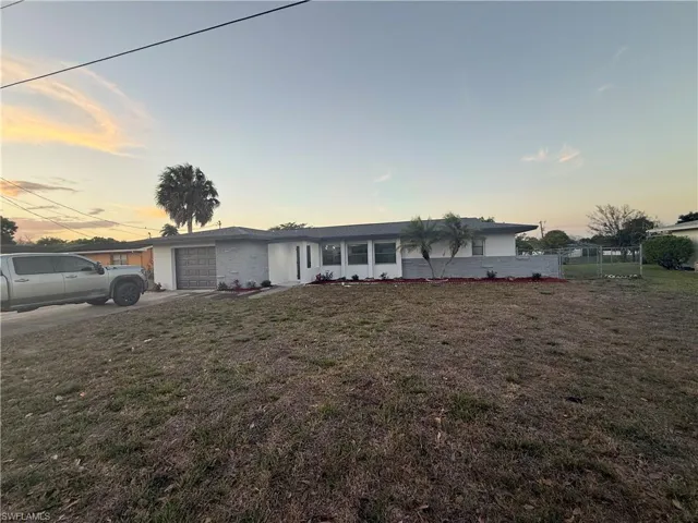 Ranch-style house featuring an attached garage, concrete driveway, and brick siding