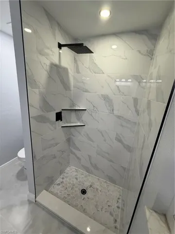 Bathroom featuring a shower stall and recessed lighting