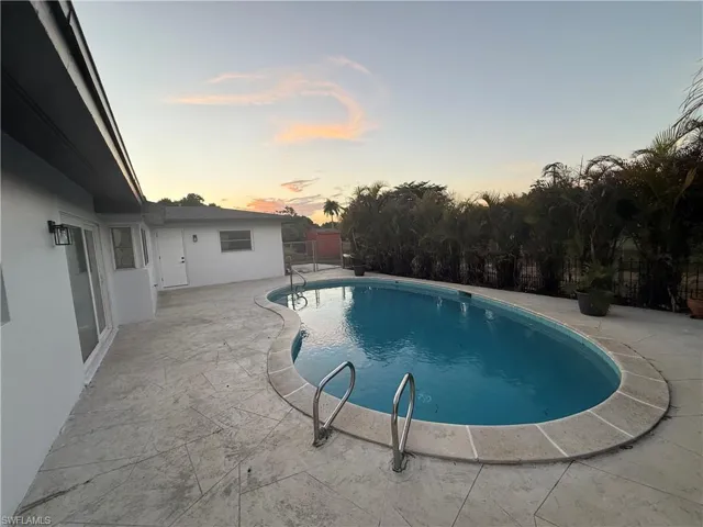Pool at dusk with a patio area