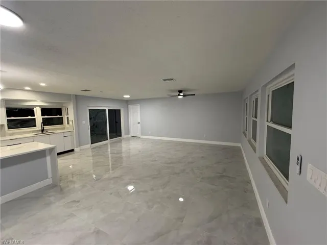 Unfurnished living room featuring ceiling fan, a textured ceiling, recessed lighting, and light marble finish floors