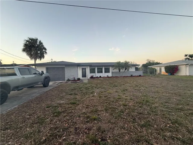 Ranch-style house with a garage and concrete driveway