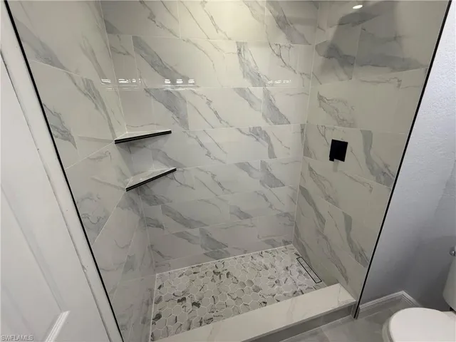 Bathroom featuring a shower stall and toilet