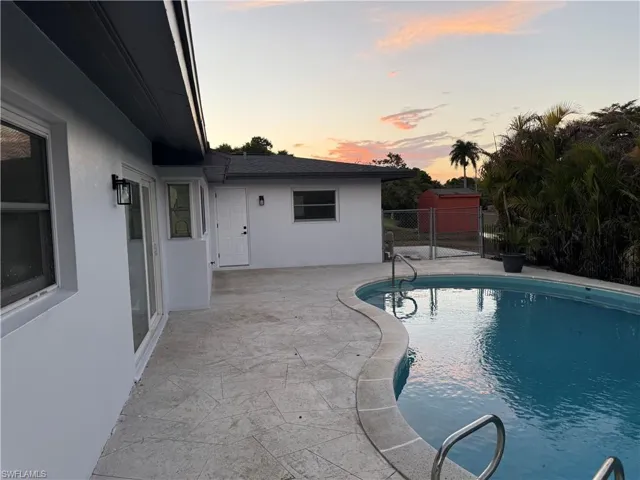 Pool at dusk with a patio area