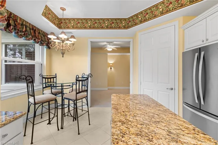 Dining area featuring light colored carpet, ceiling fan, and a chandelier