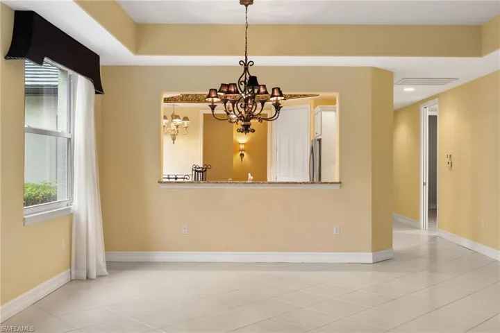 Spare room with a chandelier, recessed lighting, and light tile patterned flooring