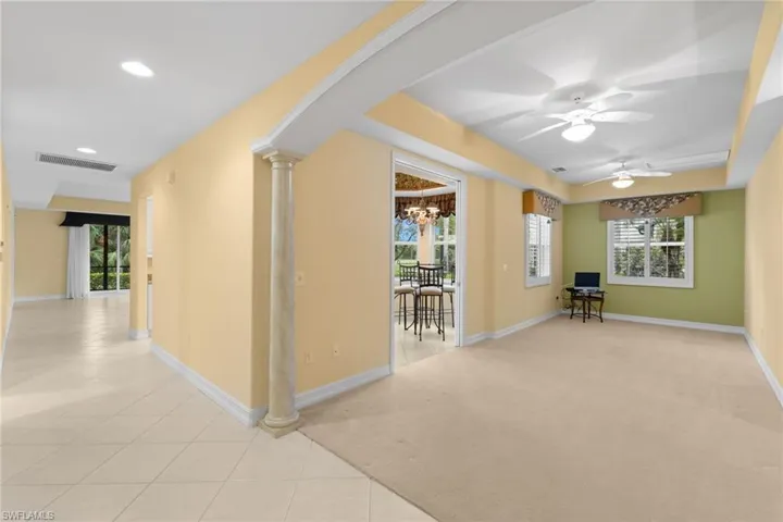 Hall with a chandelier, arched walkways, decorative columns, plenty of natural light, and recessed lighting