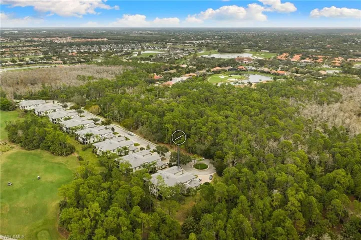 Aerial perspective of suburban area with a golf course and a nearby body of water
