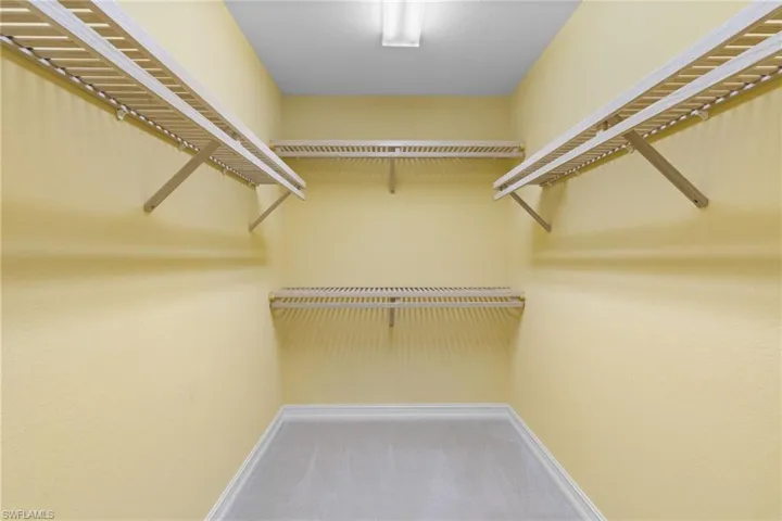 Walk in closet featuring light carpet