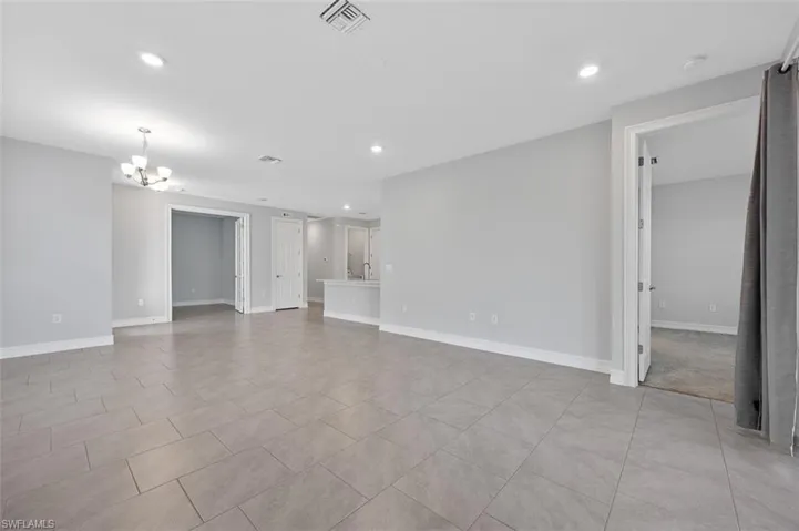 Unfurnished room with a chandelier, recessed lighting, and light tile patterned floors