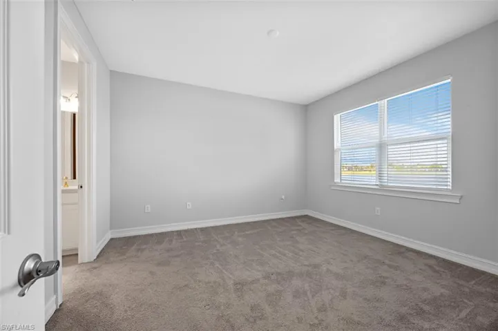 Unfurnished room featuring light colored carpet and baseboards