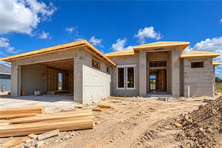 New construction featuring concrete masonry unit exterior, roof framing, multi-car garage, and window installations