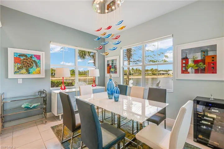 Dining space featuring healthy amount of natural light, a water view, and light tile patterned floors