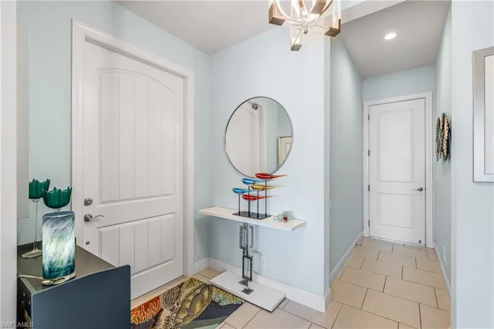 Entrance foyer with hanging lights and light tile patterned flooring