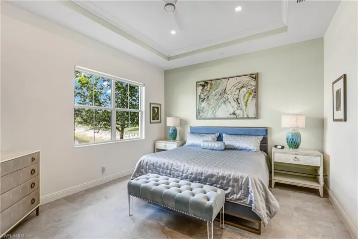 Bedroom with ornamental molding, a tray ceiling, a ceiling fan, and recessed lighting