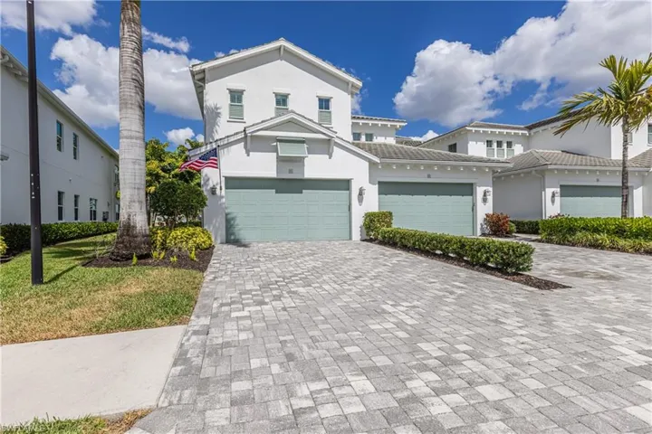 View of front of property featuring stucco siding, decorative driveway, a garage, and a tiled roof