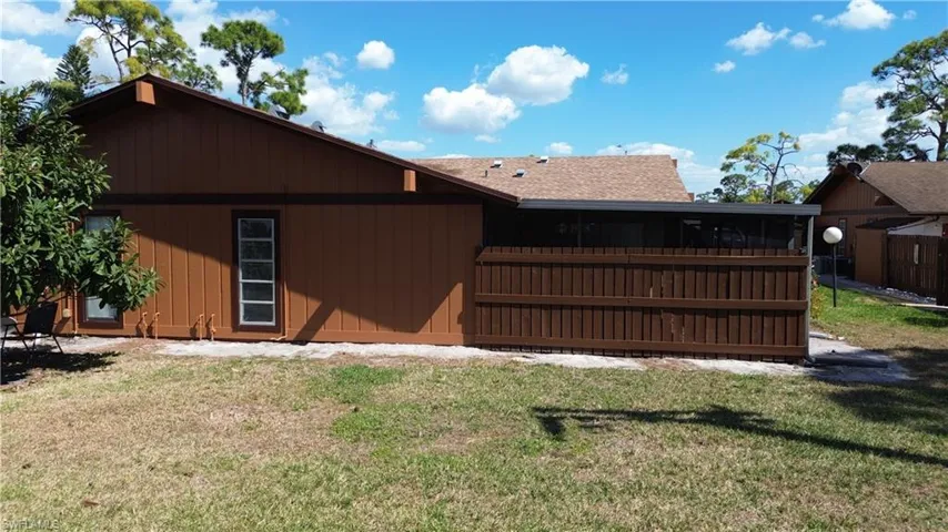 View of side of home with a yard and a shingled roof
