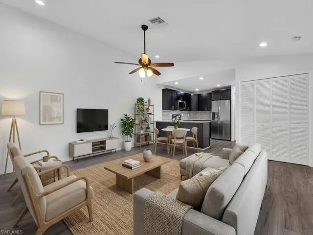 Living room featuring lofted ceiling, ceiling fan, wood finished floors, and recessed lighting - Virtually Staged