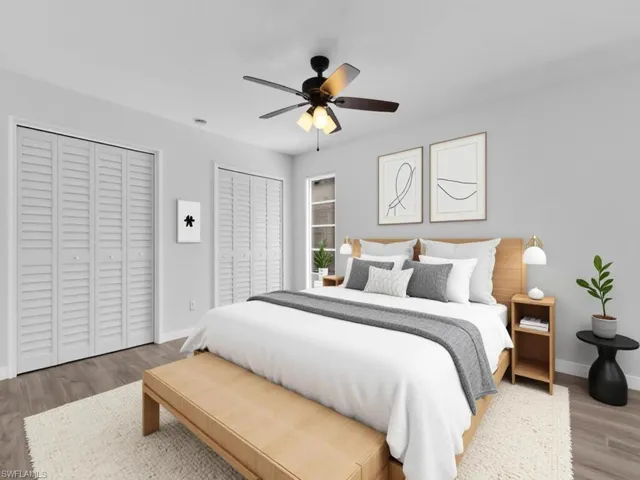 Bedroom with two closets, wood finished floors, and ceiling fan - Virtually Staged