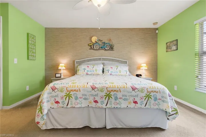 Carpeted bedroom featuring ceiling fan