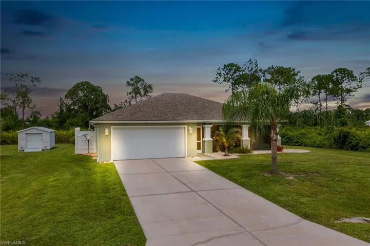 Ranch-style home with a garage and a lawn