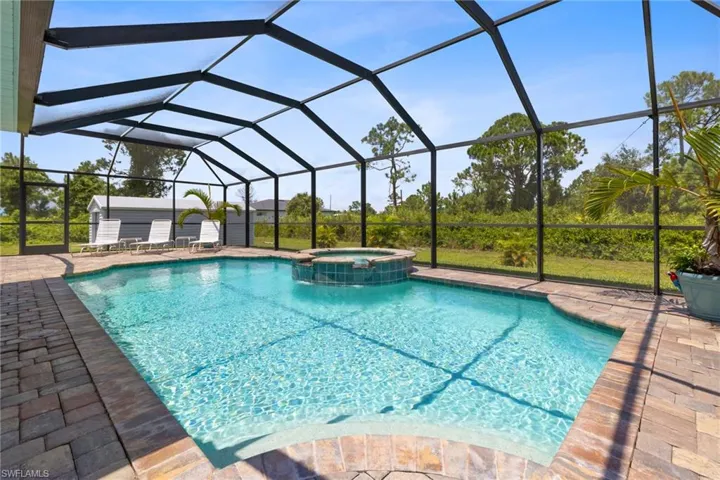 View of swimming pool with a lanai, an in ground hot tub, and a patio area