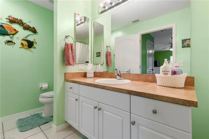 Bathroom featuring tile patterned floors, vanity, toilet, and ceiling fan