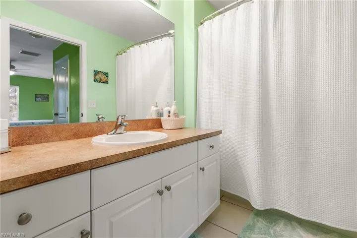 Bathroom featuring ceiling fan, vanity, and tile patterned flooring