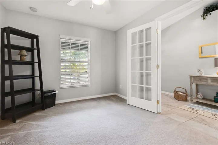 Empty room featuring lofted ceiling, light colored carpet, and ceiling fan
