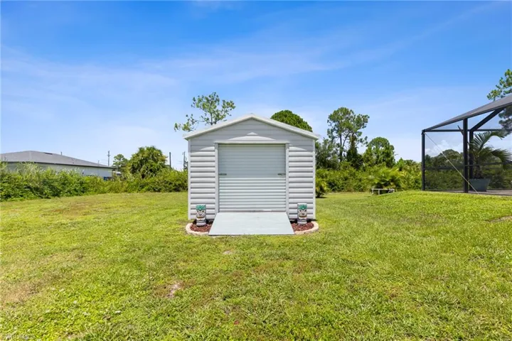 View of yard featuring glass enclosure and an outdoor structure