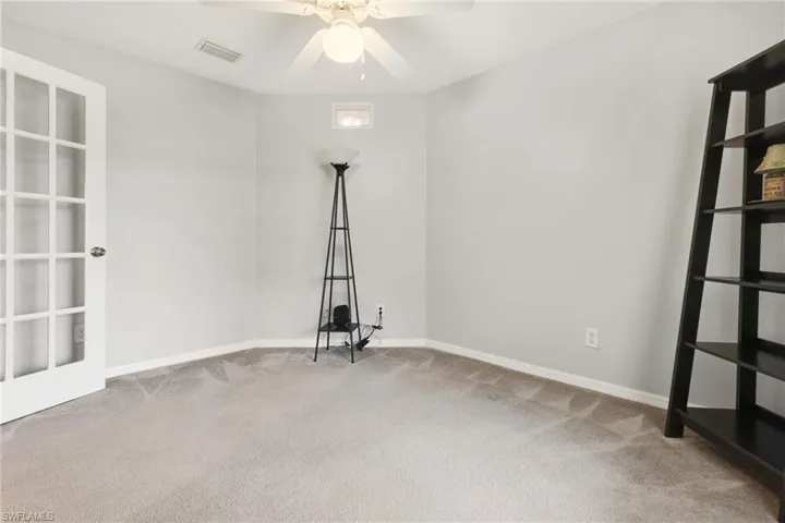 Carpeted empty room featuring ceiling fan
