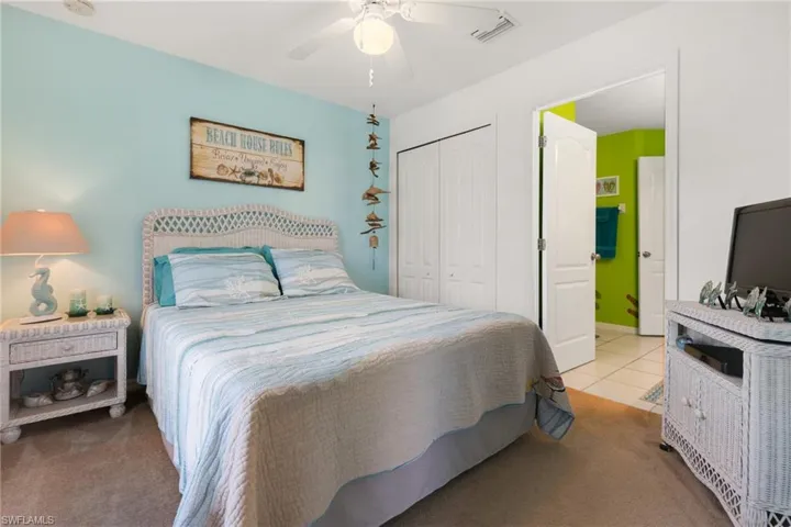Bedroom featuring light carpet, a closet, and ceiling fan