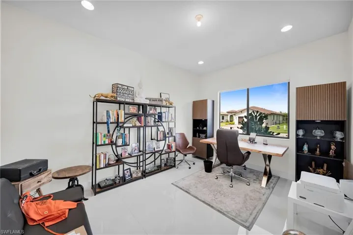 Expansive room featuring white walls and large format tile flooring