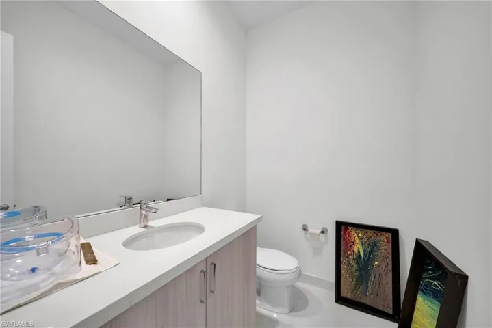 Bathroom vanity with a rectangular undermount sink, a chrome faucet, and a stone-finish countertop