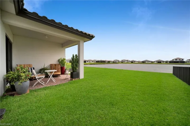 Covered outdoor patio area featuring brick-patterned flooring and a white stucco exterior wall