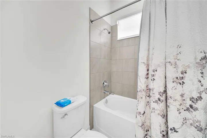Bathtub and shower combination featuring neutral tile surround